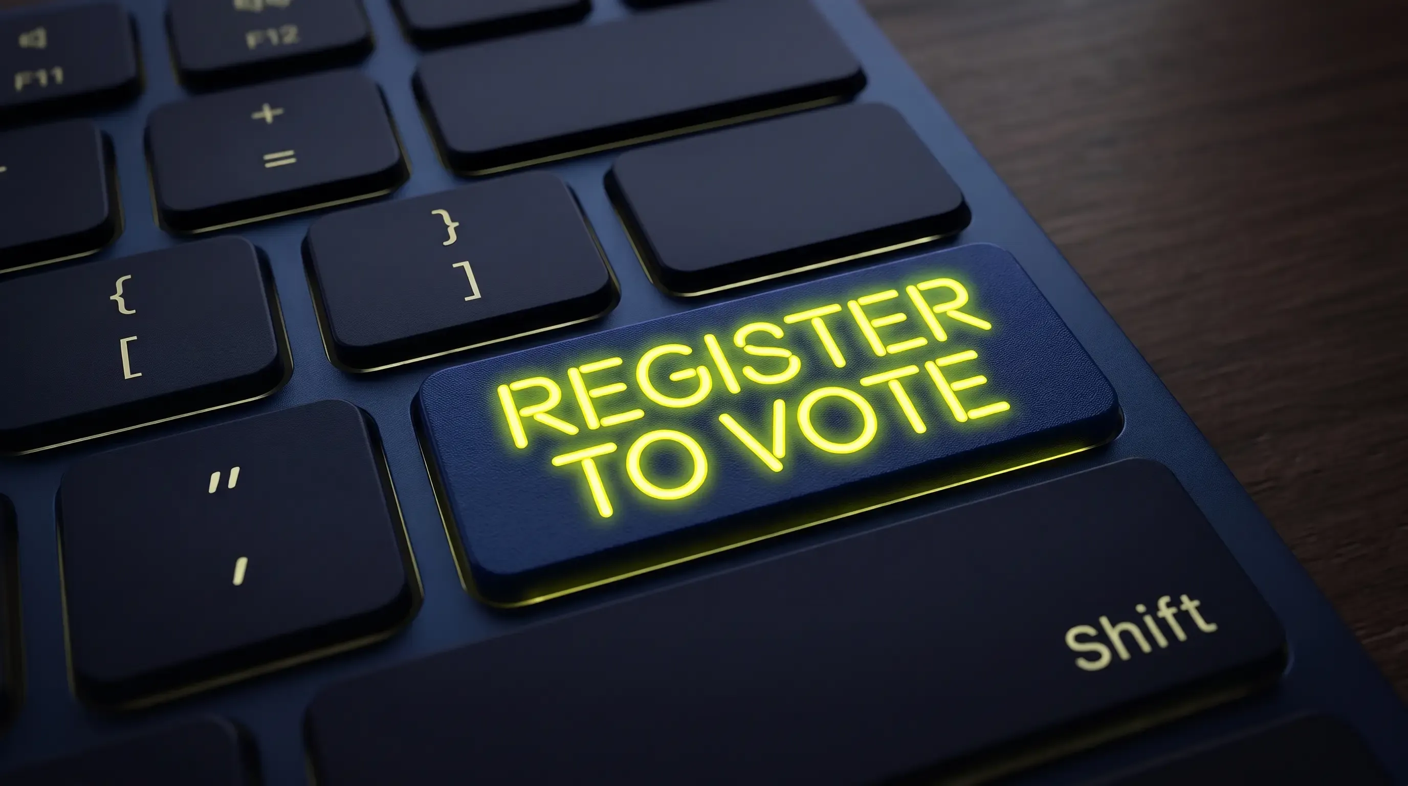 A close-up of a navy blue keyboard with a button saying “Register to vote”.