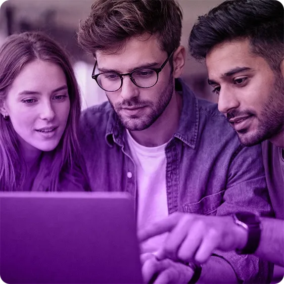 An image of three people gathered around a laptop