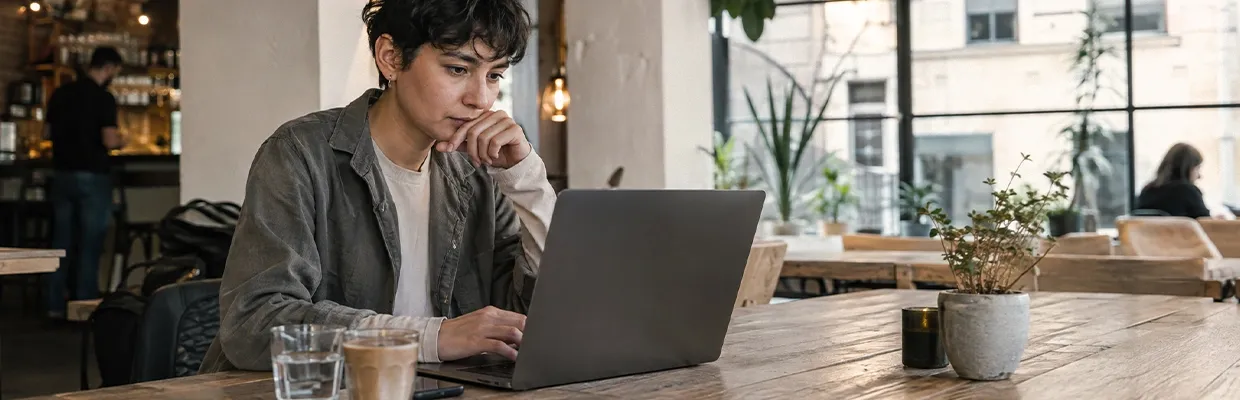 A woman uses her laptop in a coffee shop